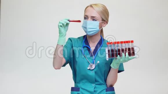 戴防护面罩和乳胶手套的女医生持血试管架视频的预览图