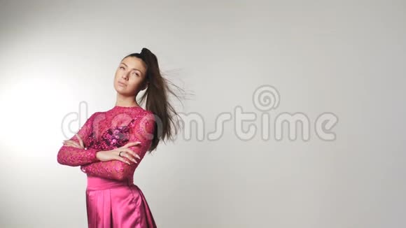 美丽的年轻女子穿着樱花花色连衣裙头发随风飘扬视频的预览图