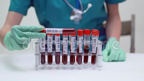 戴防护面罩和乳胶手套的护士医生使用血液试管架视频的预览图