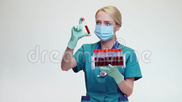 戴防护面罩和乳胶手套的女医生持血试管架视频的预览图
