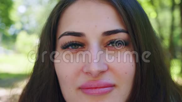 美丽的西班牙裔女孩在夏季公园睁开眼睛快关门前景视频的预览图
