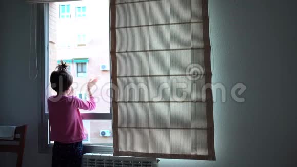 女孩在窗户上鼓掌支持对抗冠状病毒的人视频的预览图