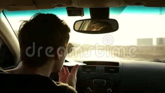 开车的人在开车时使用电话聊天和开车电话上的音频信息视频的预览图