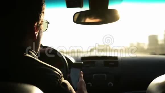 一个戴太阳镜的成年人白天开车的近景明亮的阳光照在他的眼睛里视频的预览图