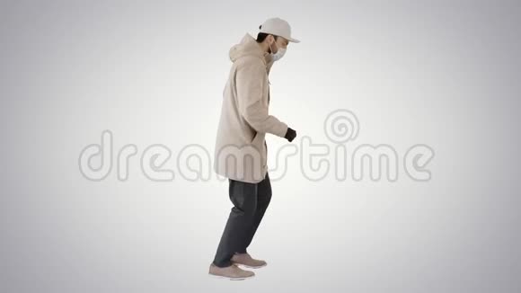 年轻人穿着户外衣服和医用面具在梯度背景下慢跑视频的预览图