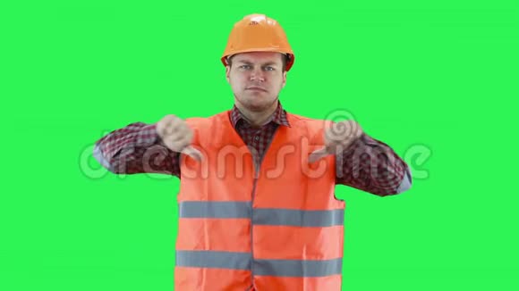 戴着建筑头盔和橙色背心的人用手显示一切都很糟糕绿色屏幕背景视频的预览图