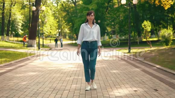 穿着休闲白衬衫和运动鞋的女性在户外散步视频的预览图