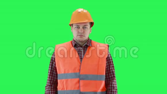 戴着建筑头盔和橙色背心的人耸耸肩绿色屏幕背景视频的预览图