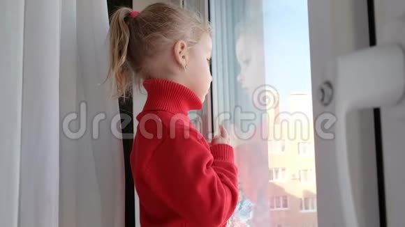 可怜的小女孩望着窗外呆在家里隔离隔离概念病毒流行爆发视频的预览图