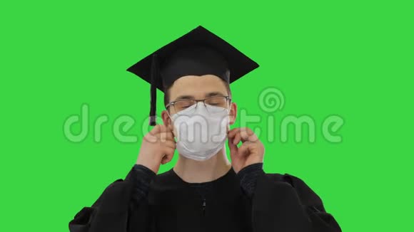 快乐的男人穿着红色长袍在绿色屏幕上摘下医用口罩病毒Chroma键视频的预览图