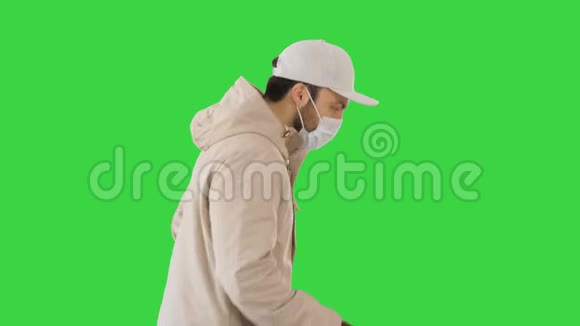 穿着夹克和戴着医用面具的秃头男人在绿色屏幕上奔跑Chroma键视频的预览图