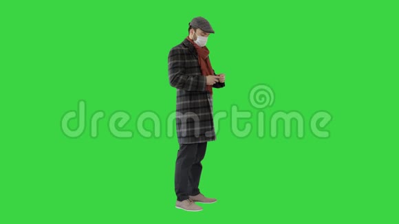 男人穿着战衣戴着保护面具用消毒剂在绿色屏幕上洗手Chroma键视频的预览图