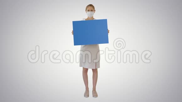 女商人戴着医疗面具在渐变背景上举着空白板标志视频的预览图
