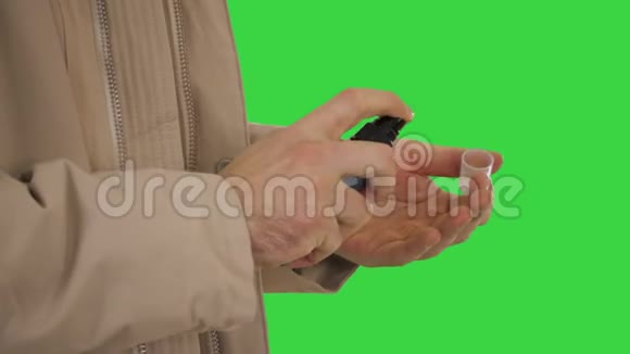 白种人的手使用绿色屏幕上的消毒剂铬键视频的预览图