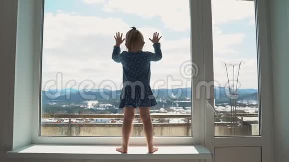 孩子在窗外与世隔绝哭着想在外面玩一个小女孩撞到玻璃上视频的预览图