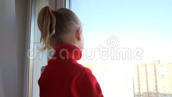 可怜的小女孩望着窗外呆在家里隔离隔离概念病毒流行爆发视频的预览图