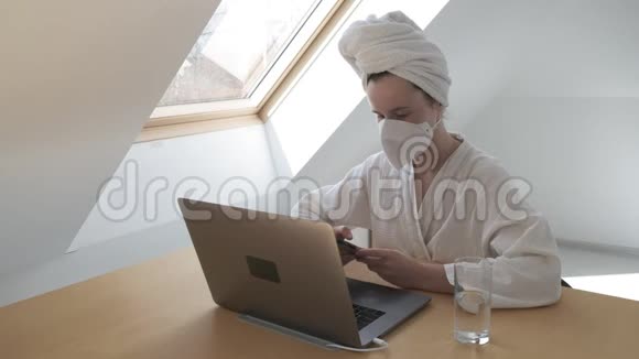 戴防护面罩的妇女在检疫冠状病毒时在家远程工作视频的预览图