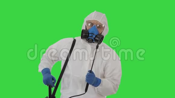 穿着个人防护装备套装手套口罩和面罩的男士准备在绿色屏幕上消毒视频的预览图