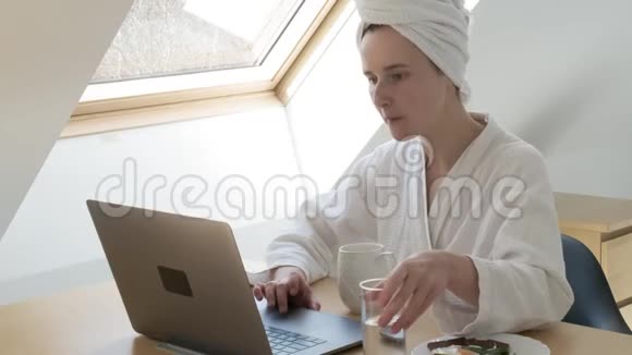 自由职业者穿白色浴袍头上有毛巾呆在家里检疫概念视频的预览图