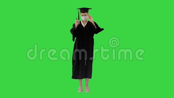 毕业学生在医疗面具使用消毒剂在绿色屏幕铬键视频的预览图