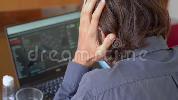 一个戴着面罩的年轻人看着电脑屏幕电脑屏幕上有多少人感染了视频的预览图