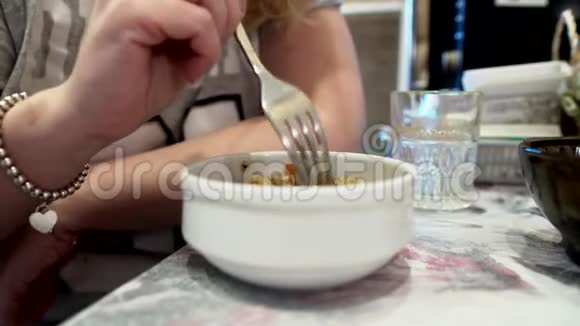 女孩吃白色盘子里的米饭视频的预览图