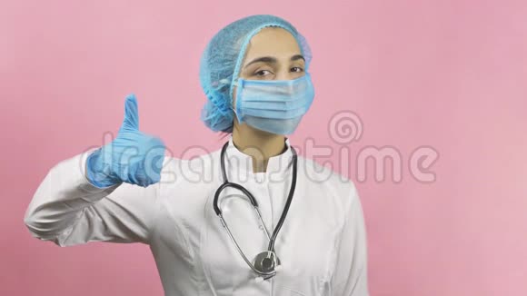 戴面罩和戴手套的女医生竖起大拇指视频的预览图