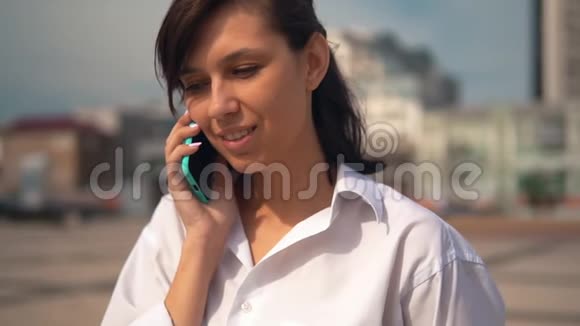 关闭年轻的白种人女人在户外通过电话交谈视频的预览图