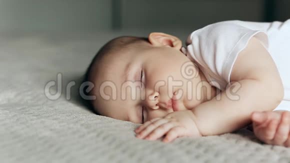 睡在灰色毯子上的可爱小男孩视频的预览图