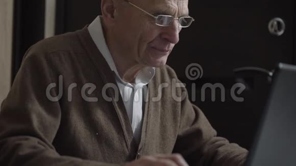 退休男子使用笔记本电脑与同学交流视频的预览图