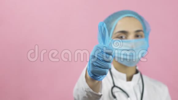 戴面罩和戴手套的女医生竖起大拇指视频的预览图