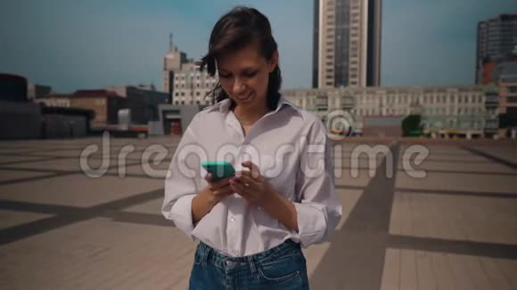 穿着白色衬衫的女人在智能手机上滚动触摸屏视频的预览图