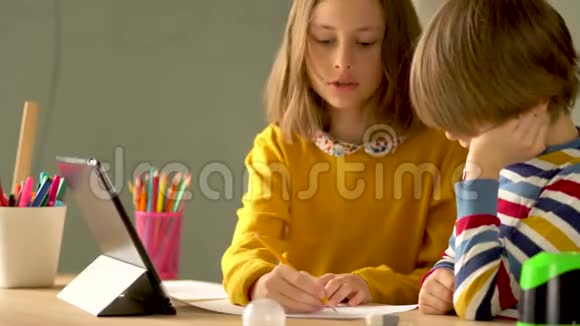 可爱的孩子使用笔记本电脑进行教育在线学习家庭学习男孩和女孩有远程学习的家庭作业视频的预览图