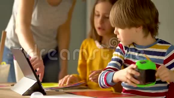 可爱的孩子使用笔记本电脑进行教育在线学习家庭学习男孩和女孩有远程学习的家庭作业视频的预览图