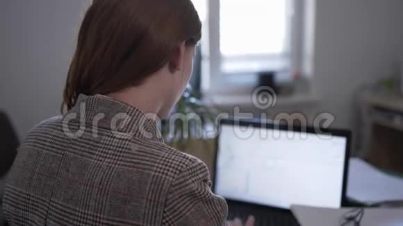 由于加班和长时间的电脑工作年轻妇女在电脑工作时因姿势不当而感到颈部疼痛视频的预览图