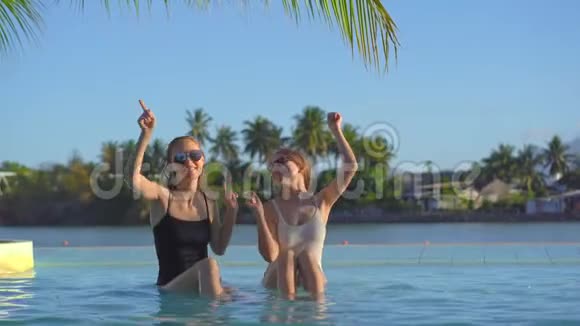 在热带度假胜地有温泉瀑布和温泉年轻女性可以在有矿泉水的游泳池里玩视频的预览图