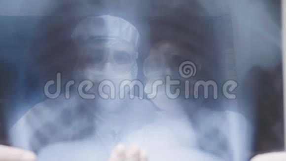 医生站在白色背景下检查X光检查一个covid19病人的肺炎在诊所冠状病毒视频的预览图