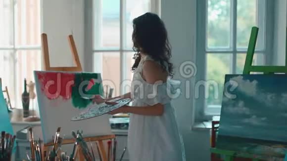 女画家用画笔和油画颜料作画视频的预览图