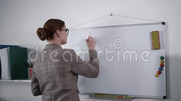 年轻女性商务女性或教师用可擦除的标记在白板上为学生写作业视频的预览图