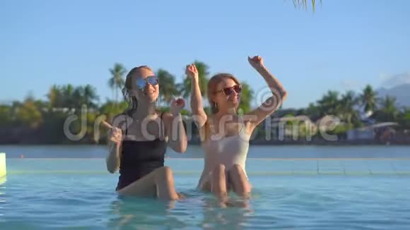 在热带度假胜地有温泉瀑布和温泉年轻女性可以在有矿泉水的游泳池里玩视频的预览图