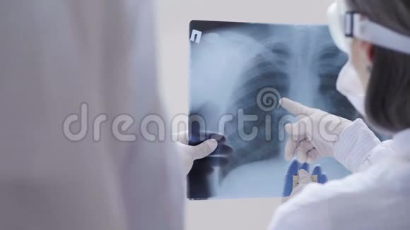 医生站在白色背景下检查X光检查一名Covid19病人在诊所的肺炎冠状病毒视频的预览图