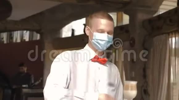 一位戴着医疗面具的欧洲侍者端着拉丁咖啡视频的预览图