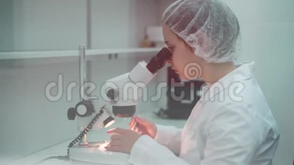 女科学家开始使用显微镜微生物学家看显微镜微生物实验室研究视频的预览图