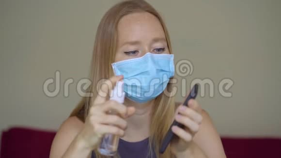 一位戴着面罩的年轻女子在冠状病毒自我隔离期间在家工作她用酒精消毒器视频的预览图