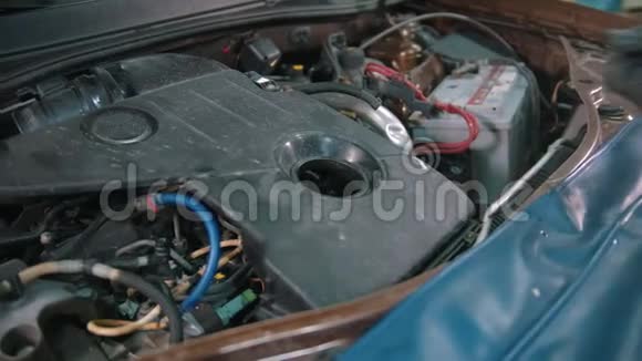 汽车修理店男工在汽车罩下拆下发动机盖视频的预览图
