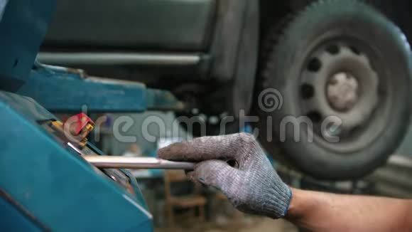汽车修理店维修服务结束后青年工人将汽车吊下视频的预览图