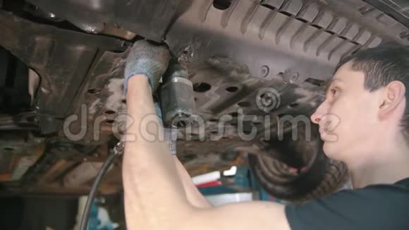 汽车修理店男工断开汽车下面的盖子视频的预览图