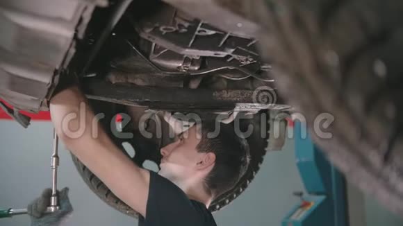 汽车修理店年轻人用扳手在车底下工作视频的预览图