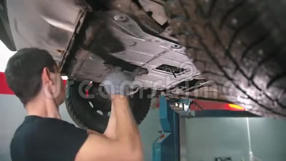 汽车修理店在车底下工作的年轻人视频的预览图