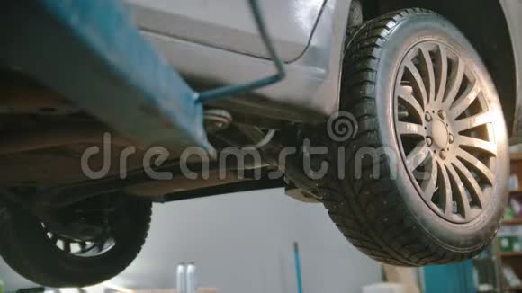 汽车修理店一名工人拿着手电筒来到一辆车前视频的预览图